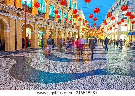 MACAU - JANUARY 11, 2016 - Tourist visiting Senado Square in the evening. This square is the largest in Macau. Macau is a former Portuguese colony.