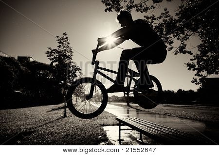 chlapec skákání přes lavičku na bmx