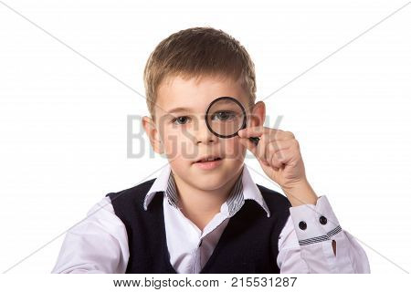 Macro, smart smiling pupil holding magnifier near the eye on the clean white background.