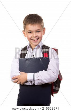 Happy cheeerful school boy hugging a black tablet folder in his hands. Standing on the clean white background.