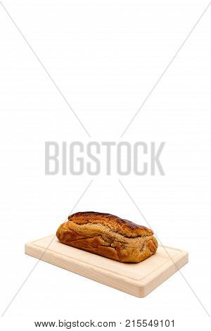 A homemade plumcake standing on a wooden board with a white background