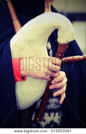 Bagpiper Playing The Bagpipes In The Christmas Period With Vinta