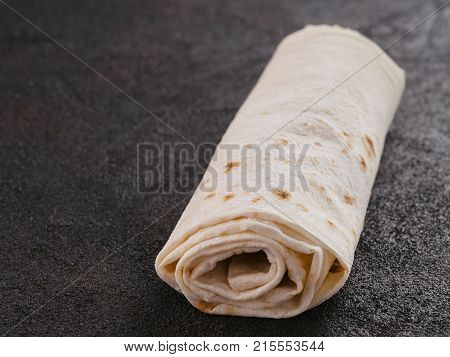 Armenian flat bread lavash. Pita bread on black cement background. Copy space.