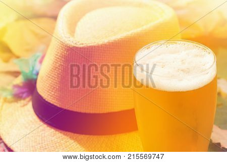 Beer glass pint octoberfest picnic on background with hat and autumn yellow leaves
