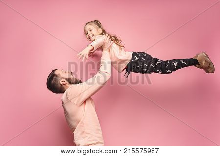 The surprised and cheerful father playing with daughter at pink studio