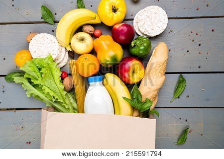 Grocery Shopping Concept. Different Food In Paper Bag On Wooden Background.  Flat Lay.