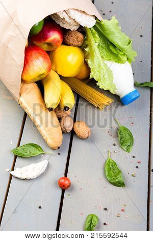Grocery Shopping Concept. Different Food In Paper Bag On Wooden Background.  Flat Lay.