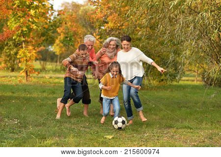 Big happy family playing football in park