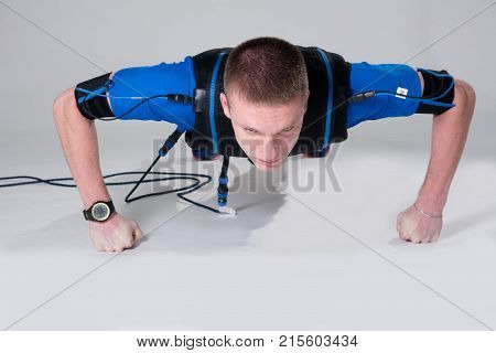 Man In An Electric Muscular Suit For Stimulation Does Push-ups On The Fists
