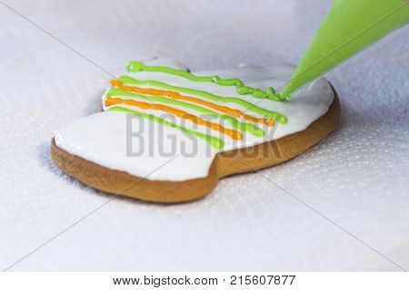 Decorating Gingerbread With Icing Sugar Using A Green Pipping Bag. Handmade Cookies In The Form Of A