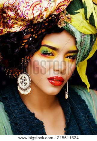 beauty bright woman with creative make up, many shawls on head like cubian, ethno look close up