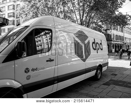 STRASBOURG FRANCE - OCTOBER 3 2017: DPD postal courier distributing parcels near the white delivery van parked on a French street in central town