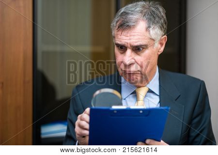 Businessman analyzing a document in his office