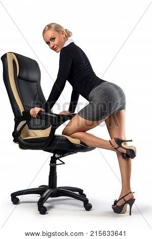 Sexy blonde secretary with perfect legs posing with the office chair - isolated on the white.