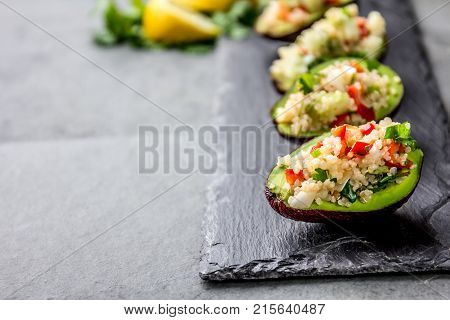 Tradition peruvian quinua quinoa salad served in avocado half, slate board.