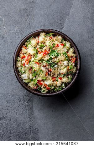 Traditional peruvian quinoa quinua salad in clay bowl, slate gray background.