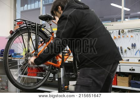 bicycle repair workshop with one orange bike and many tools