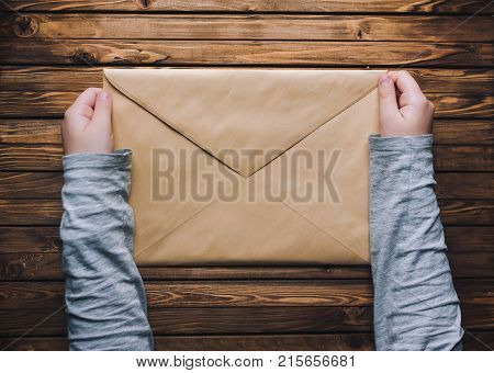 Children's hands hold a closed envelope. The package concept.