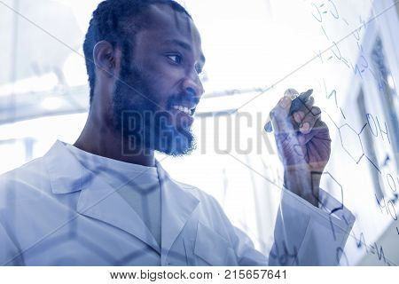 Nothing difficult. Cheerful nice positive man looking at the formula and smiling while knowing how use it