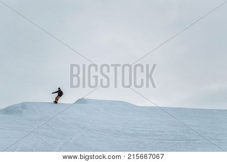 Snowboarder In A Black Helmet Riding On A Snowy Track.