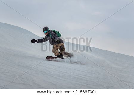 Snowboarder In A Black Helmet Riding On A Snowy Track.