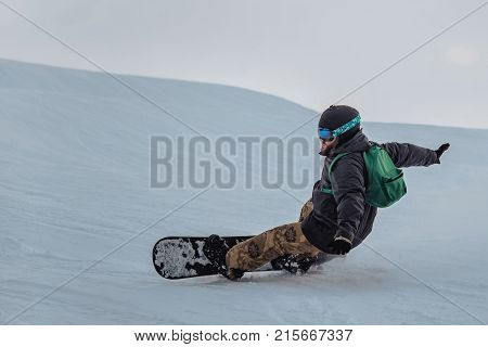 Snowboarder In A Black Helmet Riding On A Snowy Track.