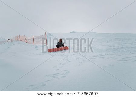 Snowboarder In A Black Helmet Riding On A Snowy Track.