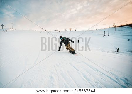 Snowboarder In A Black Helmet Riding On A Snowy Track.