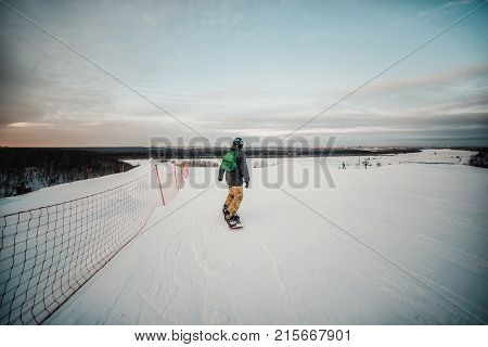 Snowboarder In A Black Helmet Riding On A Snowy Track.