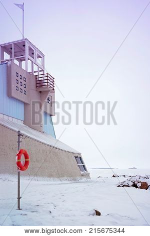 Lifebuoy and Lighthouse in the Baltic Sea in winter Oulu Lapland Finland.