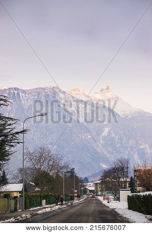 Switzerland - January 1 2015: Mountain View of road in town in winter Switzerland. Switzerland is a country in Europe. Switzerland has a high mountain range; from the Alps to the Jura mountains.