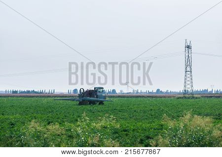 Tractor doing agricultural work in the field in Austria in summer.