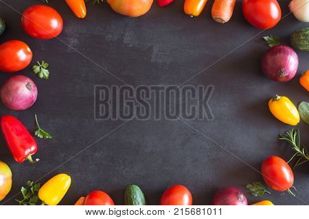 Fresh vegetables on a black chalkboard. Top view