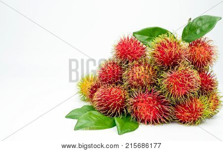 Fresh red ripe rambutan (Nephelium lappaceum) with leaves isolated on white background. Thai dessert sweet fruits.