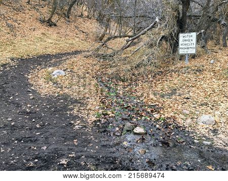Motor Driven Vehicles Prohibited by order of the Sheriff sign with bullet holes, in forest trail on the Yellow Fork and Rose Canyon Trails in Oquirrh Mountains on the Wasatch Front in Salt Lake County Utah USA.