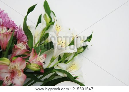 A beautiful bouquet with flowers lilies astromeria chamomile on white background