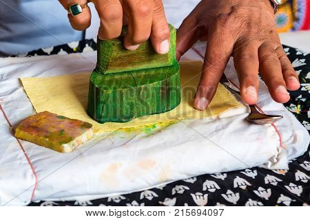 Close up stamp applying dye on cloth