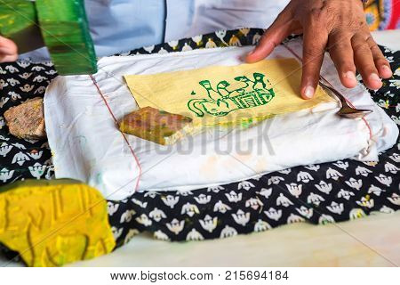 Close up stamp applying dye on cloth