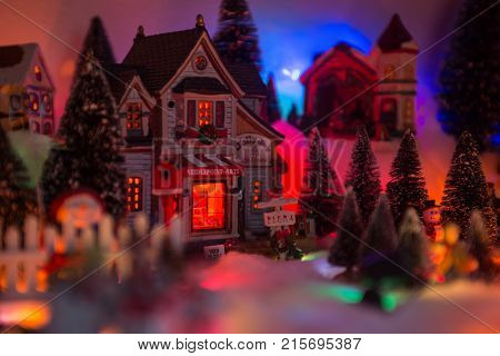 Christmas background of snow miniature village with store front reads jolly joy arts and crafts