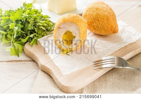 Chicken Kiev cutlets with parsley leaves and butter.