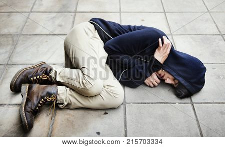 Guy in a hoodie fetal position on the floor