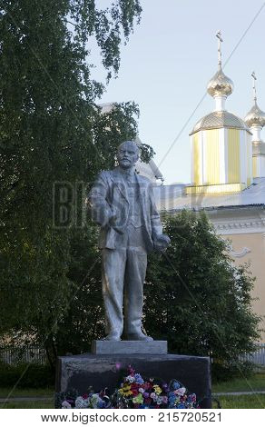 Verkhovazhye, Vologda region, Russia - June 14, 2013: Lenin monument on the background of the domes of the church in the village of Verhovazhe