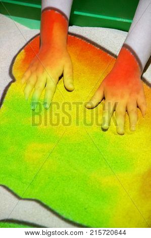 Interactive sandbox for children's games with a projector that color sand colored lights