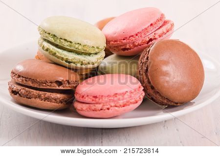 Assortment of colorful tasty macaronson white dish.