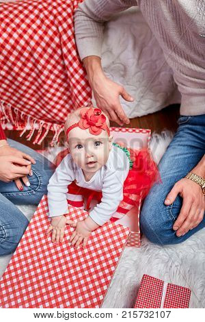 little cute girl is sitting in a gift box near her parents