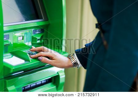 Image of girl picking pincode at green cash dispenser in room