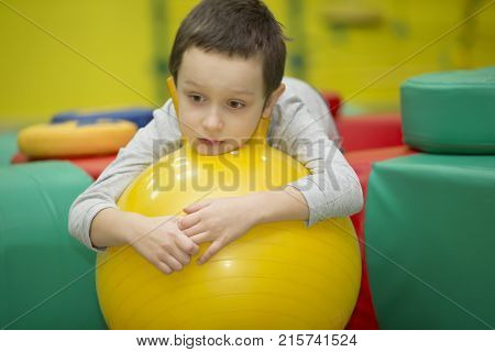 Belarus Gomel November 9 2017. Gomel Children's Center. Children's holiday.Sad child in the gym.Boy on a rubber gymnastic ball