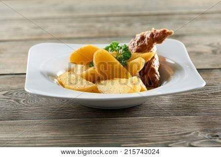 Shot of a delicious meal on a wooden table at the local restaurant fried sliced potatoes and chicken sausage food delicacy gourmet cusine cooking recipe dinner lunch concept.