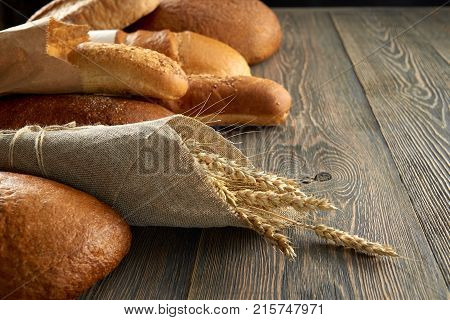 Pile of different kinds of bread on wooden worktop copyspace vintage retro countryside bakery eating healthy breakfast baking pastry nutrition dough fresh concept.