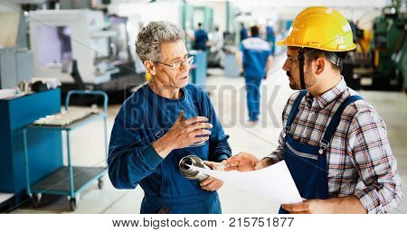 Factory worker discussing data with supervisor in metal industry factory